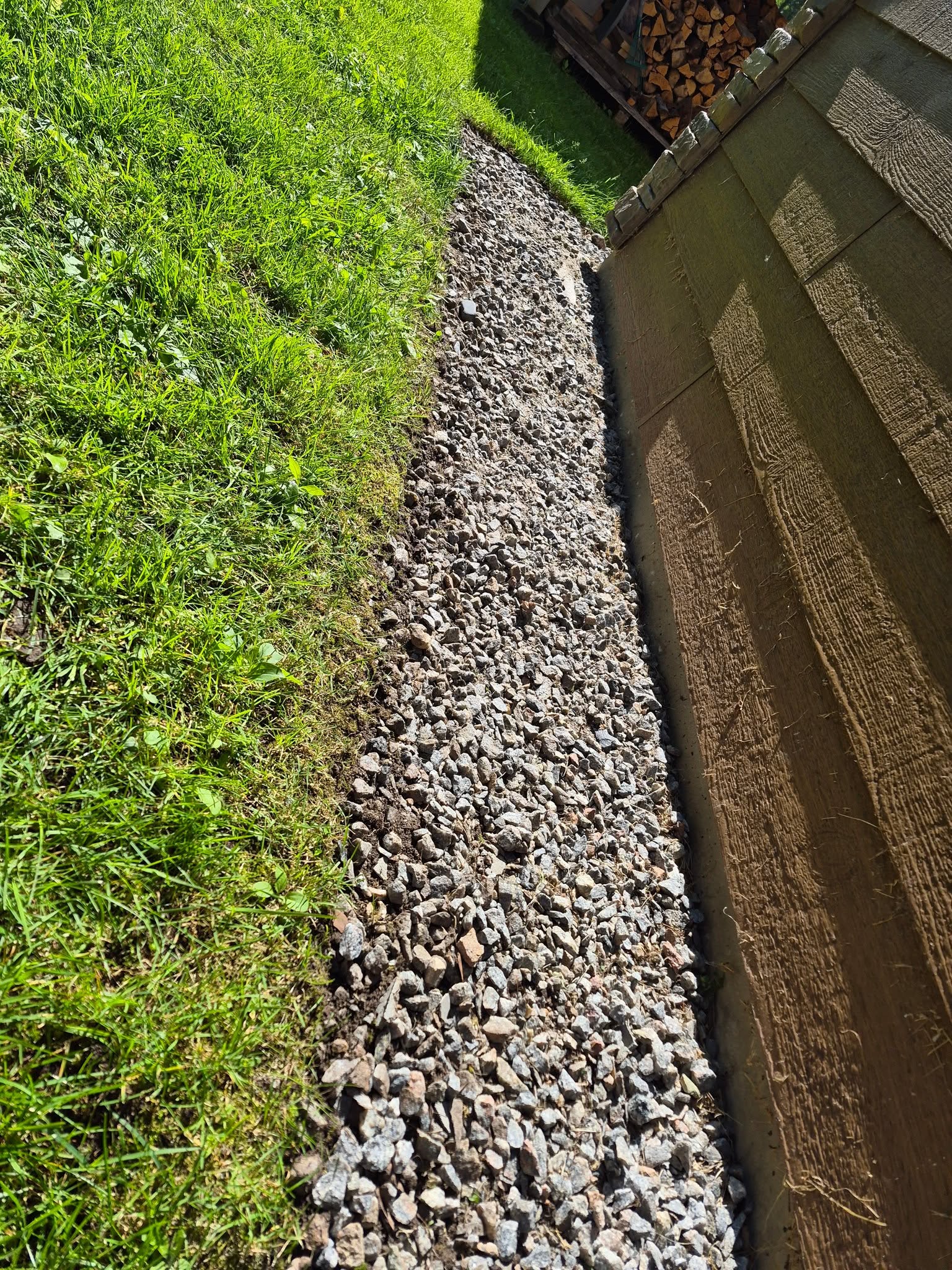 A tidy gravel border beside a house after yard cleanup